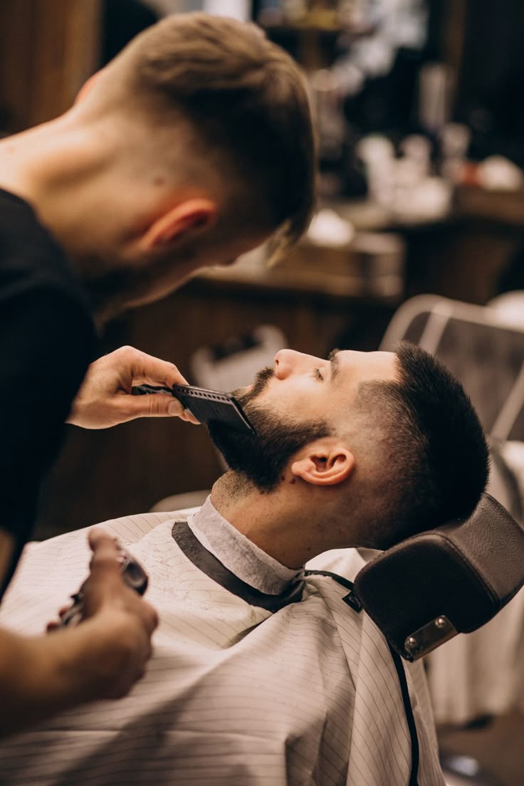 Barbeiro cuidando da barba de um cliente